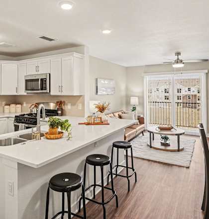 A modern kitchen with white cabinets and a large island at The Grove Apartment Homes, Lincoln, NE