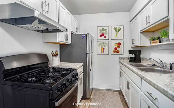 A kitchen with a black stove top oven and a refrigerator