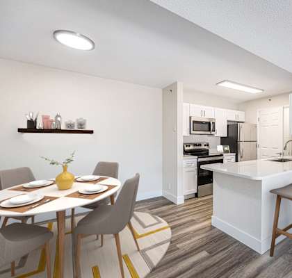 A modern kitchen with a dining table set for four.