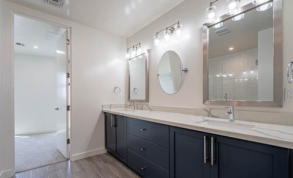 a bathroom with black cabinets and white countertops