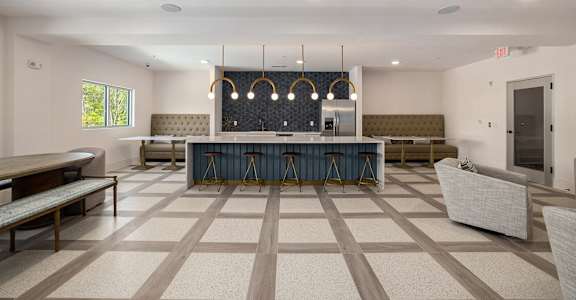 A spacious room with a bar and seating area.