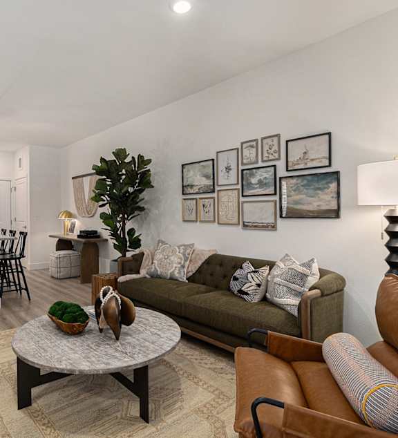 A living room with a brown leather couch and a coffee table.