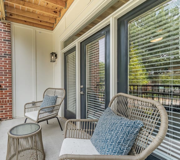 a balcony with two chairs and a table