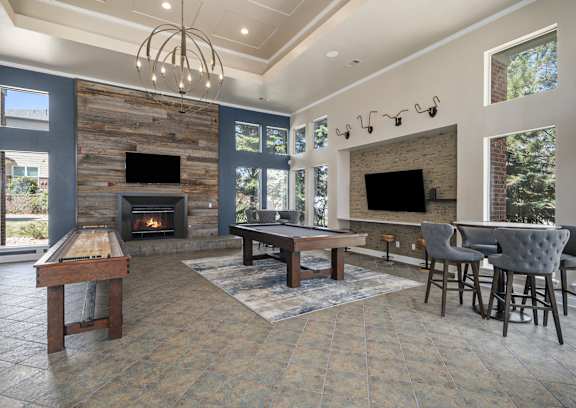 A large room with a fireplace and a pool table.