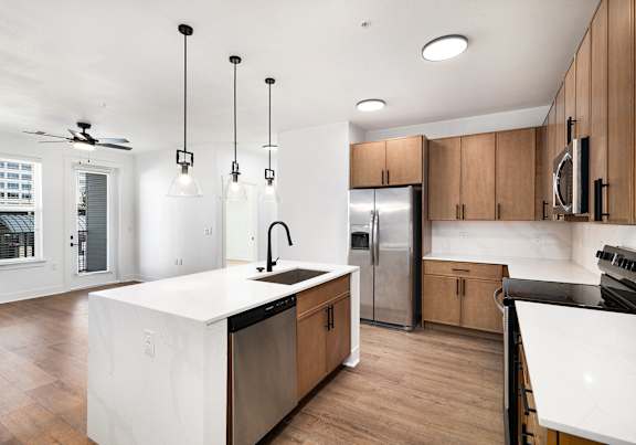 A modern kitchen with wooden cabinets and a white island.