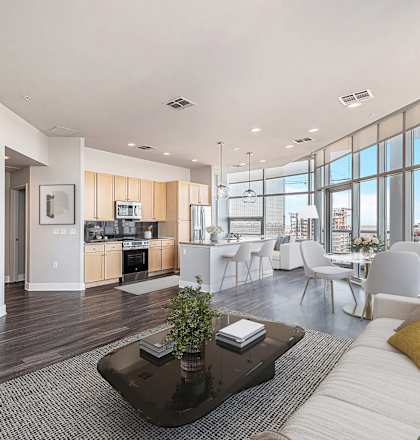 A modern living room with a white sofa, a coffee table, and a large window.