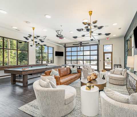 a living room filled with furniture and a pool table