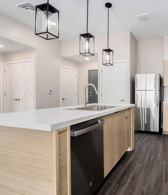A modern kitchen with a marble island and wooden cabinets.