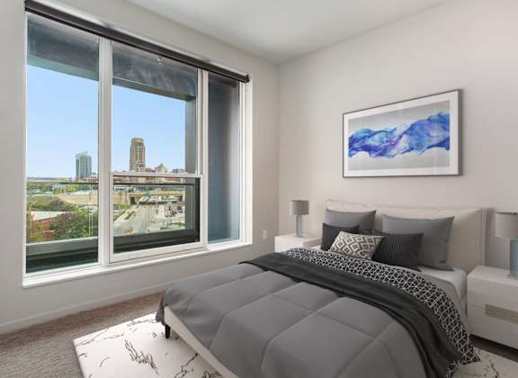 a bedroom with a bed and a window with a city view