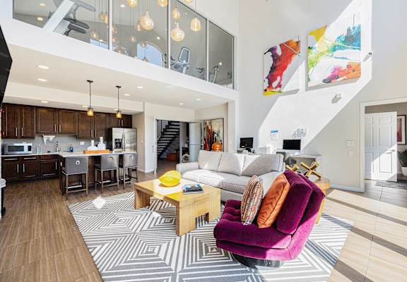 A modern living room with a purple armchair and a wooden coffee table.