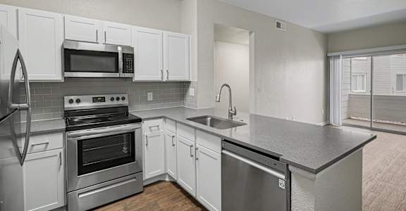 A kitchen with white cabinets and stainless steel appliances.