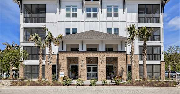 an image of a building with palm trees in front of it