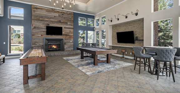 A large room with a fireplace and a pool table.