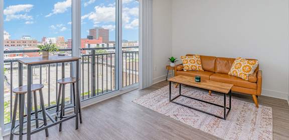 a living room with a couch and a table on a balcony  at City View Apartments, Michigan