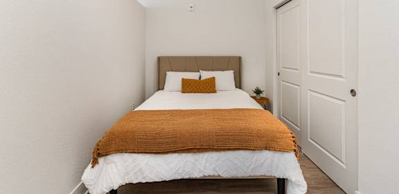 a bedroom with a bed and a closet  at City View Apartments, Michigan