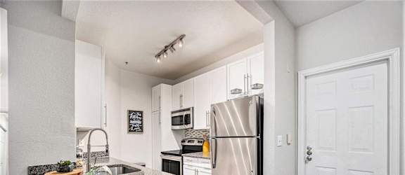 A kitchen with a granite countertop and stainless steel appliances.