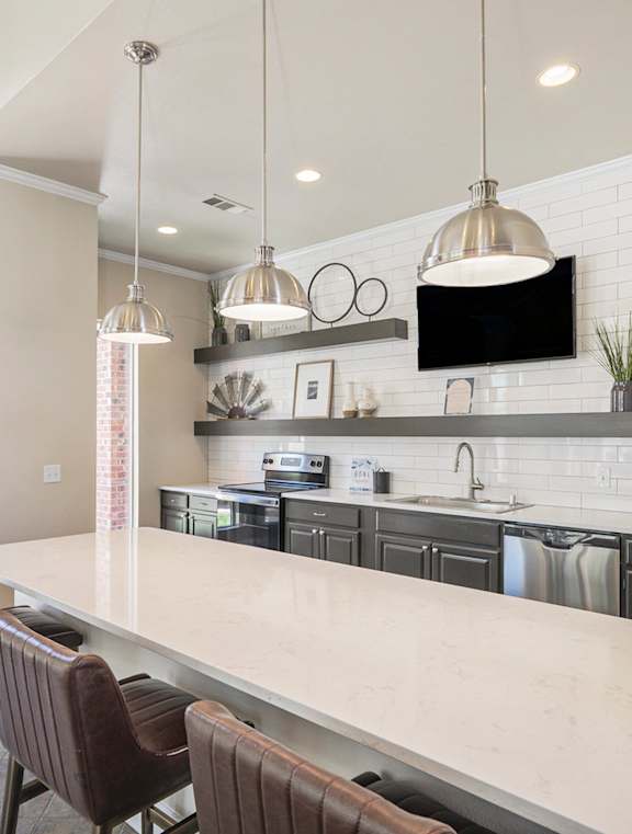 A kitchen with a long island and chairs.