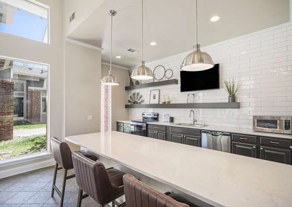 A kitchen with a long island and chairs.