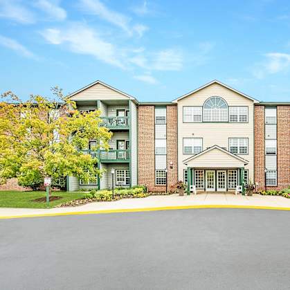 A large apartment complex with a central courtyard and a clear blue sky above.