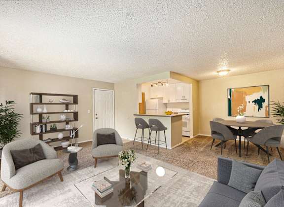 a living room with a couch and chairs and a kitchen with a table