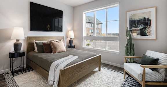 a bedroom with a bed and a large window
