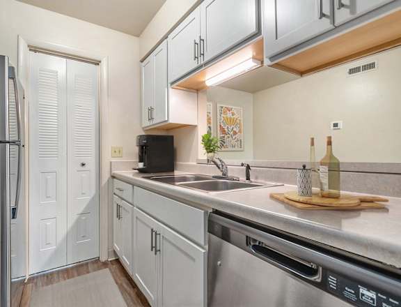 A kitchen with white cabinets and a black refrigerator at West Wind Apartments, Fort Wayne, IN