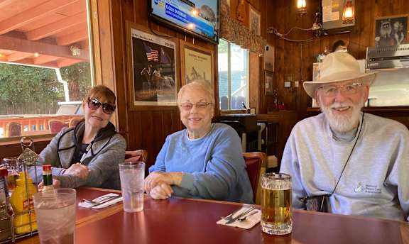 Three people sitting at a table in a restaurant.