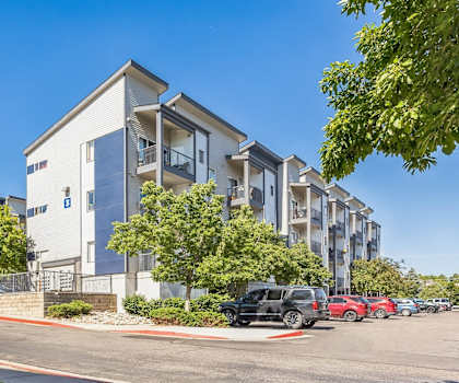 an apartment building with cars parked in front of it