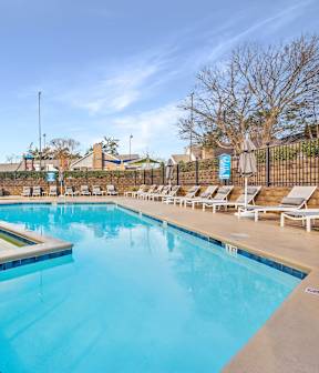 A large outdoor swimming pool with a fountain in the middle.