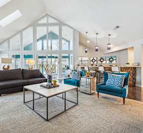 A living room with a glass wall and a skylight.
