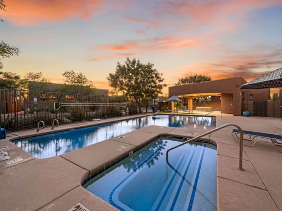 a swimming pool in front of a house with a pool