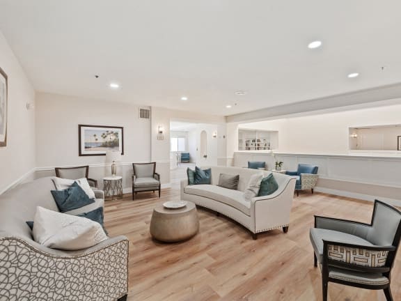 a living room with couches and chairs and a kitchen