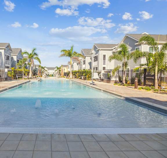 A swimming pool in the middle of a residential area with houses on both sides.