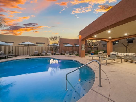 a swimming pool in front of a house with a pool