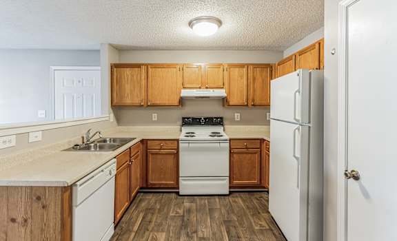 a kitchen with white appliances and wooden cabinets