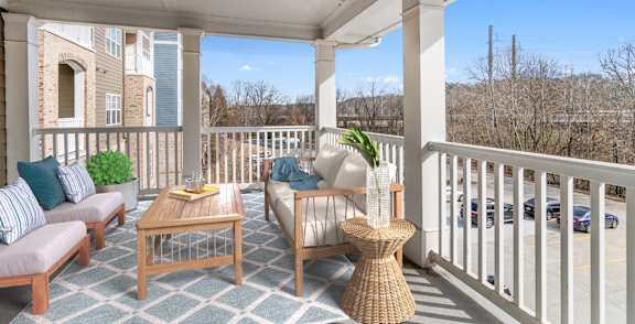A balcony with a table and chairs.