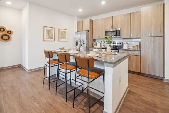 a kitchen with a island with four stools in front of it  at Palm Grove, Ellenton