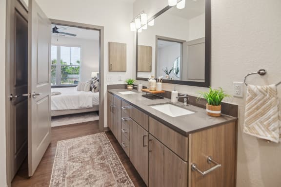 a bathroom with a sink and a mirror and a door to a bedroom  at Palm Grove, Ellenton, FL, 34222