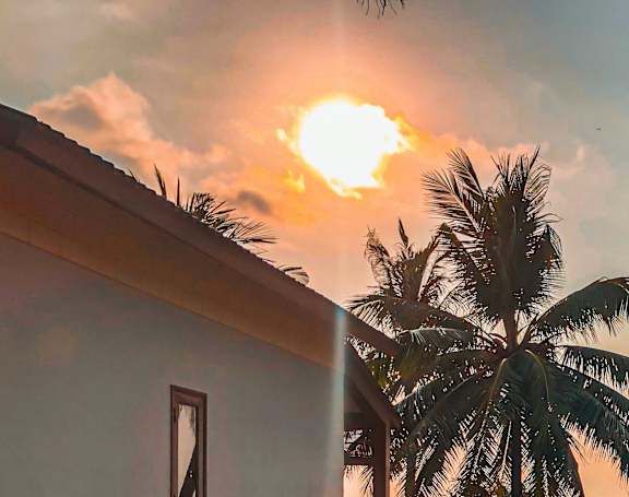A sunset view from a balcony overlooking the ocean.