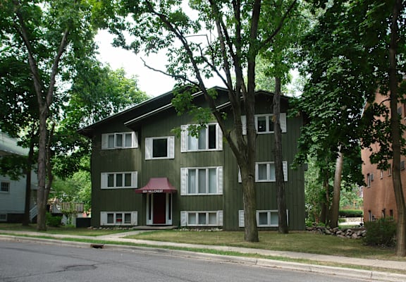 a green and white building with trees in front of it