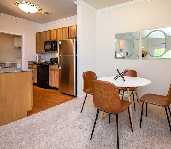 A kitchen with a table and chairs.