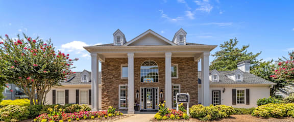 A large house with a front yard and a driveway.