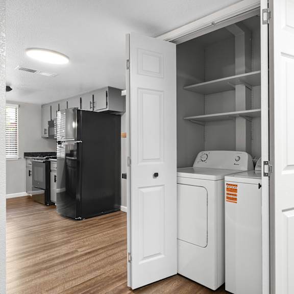 White laundry room with shelves at Redwood Cove Apartments, Chico, California