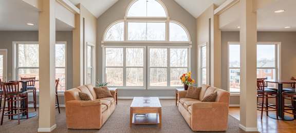 A living room with a large window and a ceiling fan.