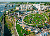 Thumbnail 4 of 7 - A large open area with a lot of people sitting on the grass.