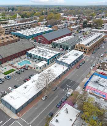 A view of a city from above with buildings, cars, and a pool.