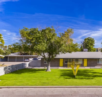 a house with a yellow sculpture in the front yard