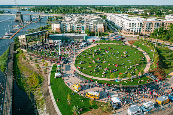 A large open area with a lot of people sitting on the grass.