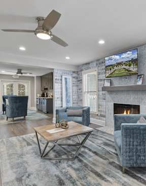 a living room with blue furniture and a brick wall  at Lakeside on Riverwatch in Martinez, GA 30907