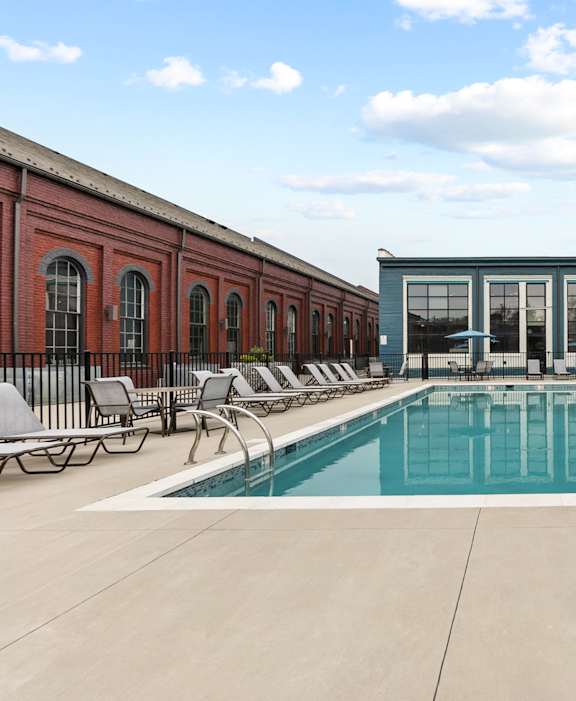 A large apartment complex with a pool in the courtyard.